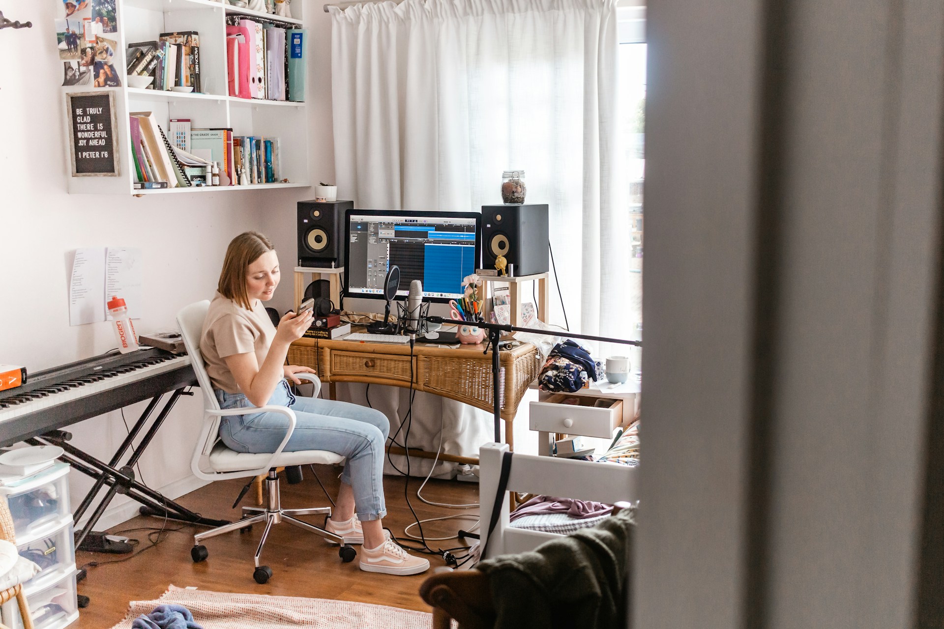 A modern home studio setup with a laptop, MIDI keyboard, and headphones, illustrating the iterative 'weaver' method.